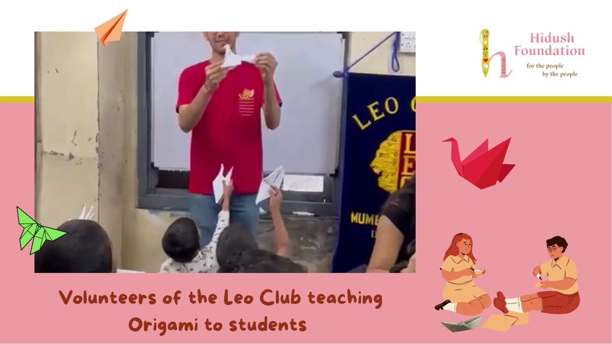 A volunteer shows the students how to fold